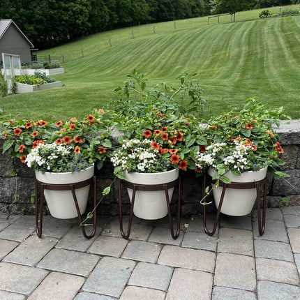 Handcrafted steel plant hangers and outdoor hooks styled on a stone farmhouse patio with potted flowers — Industrial Farm Co