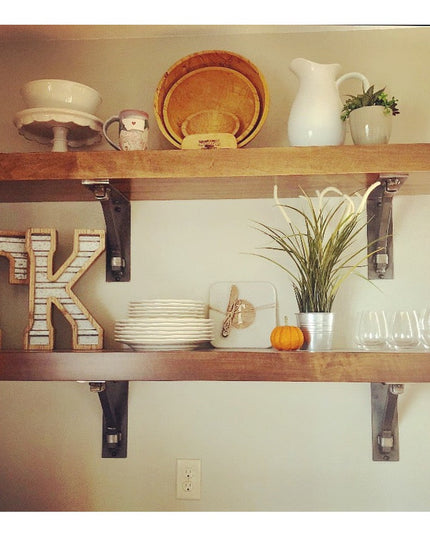 Rustic wood shelves mounted with black metal Hornell Industrial Shelf Support brackets displaying kitchen decor and dishware