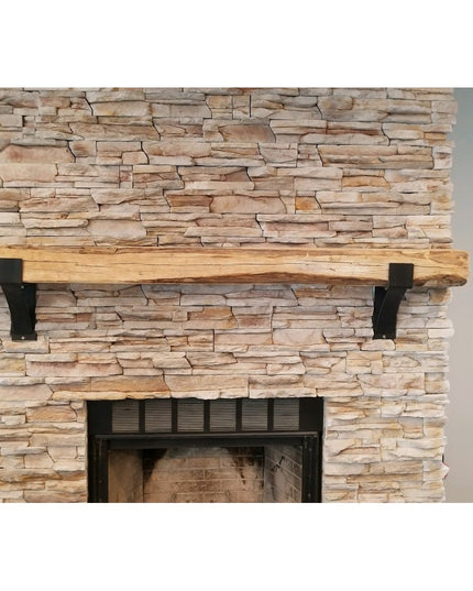 Kudlick Farmhouse black metal mantel brackets supporting rustic wood beam on natural stone fireplace wall by Industrial Fa...