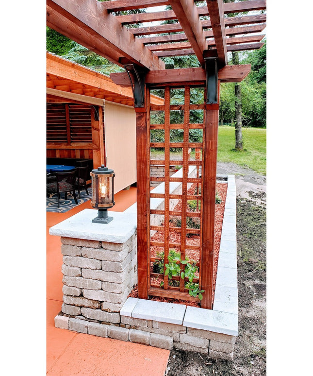 Rustic wooden pergola with cedar trellis panels and stone pillar featuring lantern, showcasing outdoor architectural desig...