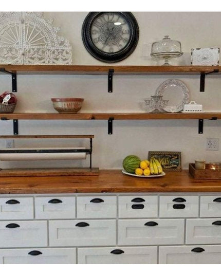 Black metal Z-style shelf brackets supporting rustic wood shelves displaying glassware and kitchen items on white farmhous...