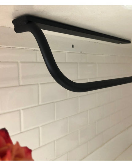 Black metal Hyde Hall Paper Towel Holder by Industrial Farm Co mounted under cabinet above white subway tile backsplash wi...