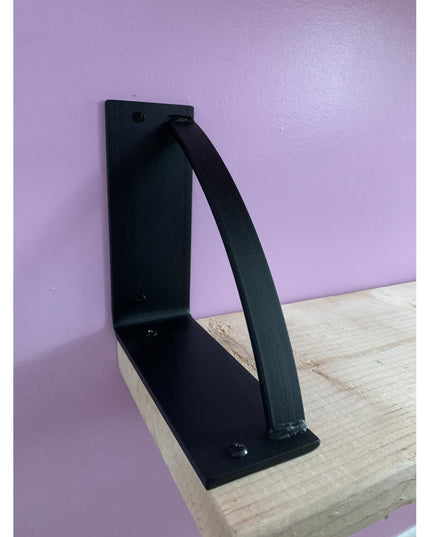 Black metal Brie bookshelf bracket by Industrial Farm Co mounted on natural wood shelf against purple wall, showing triang...