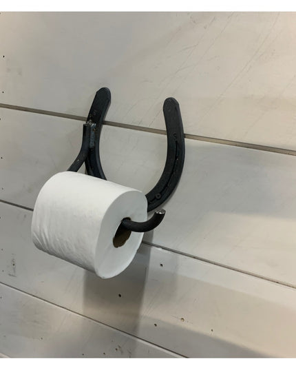 Black wrought iron horseshoe toilet paper holder mounted on white shiplap wall displaying rustic farmhouse style by Indust...
