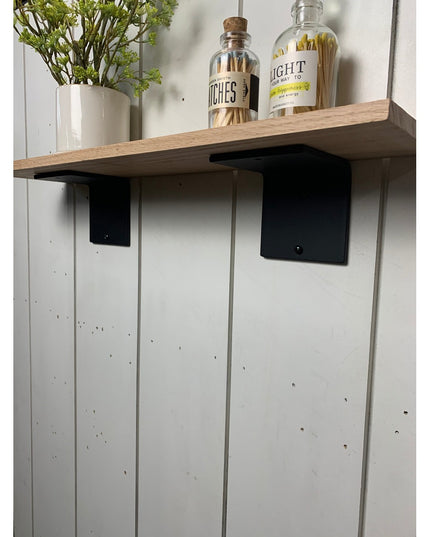 Black steel L-shaped shelf brackets supporting natural wood shelf with decorative bottles and plant vase - Industrial Farm...