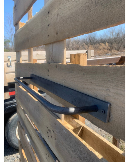 Black metal Oswego Modern Bathroom Towel Bar by Industrial Farm Co mounted on rustic wood beam during construction