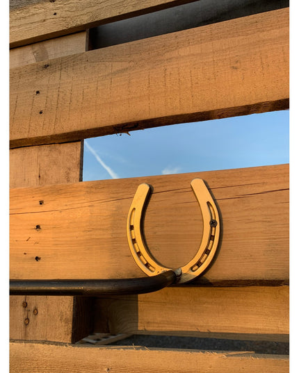 Golden horseshoe towel bar mounted on rustic wooden fence rails - The Donahue Horseshoe Blanket & Towel Bar by Industrial ...