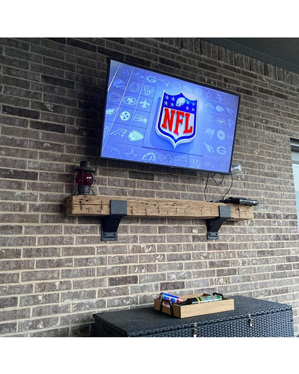 Fulton Style Heavy Duty Mantel Support brackets in black metal mounting a rustic wood beam shelf under wall-mounted TV on ...