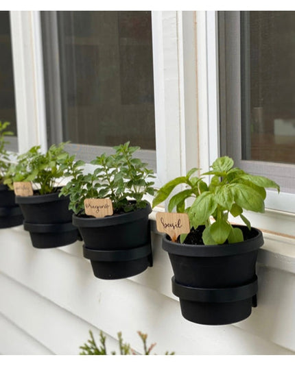 Black fabric Smoral Handmade Pot Holders by Industrial Farm Co displaying potted herbs with wooden plant labels on white w...
