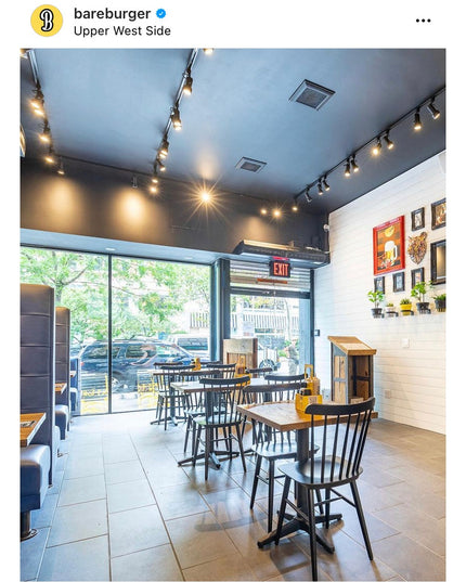 Modern restaurant interior featuring Industrial Farm Co Hudson Wall Planter Rings with small plants mounted on white brick...