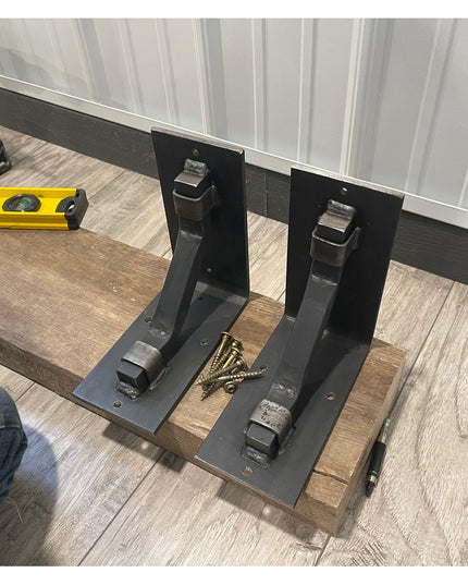 Black metal Rosamond Shelf Supports by Industrial Farm Co being installed on wood planks with drill and level tools visible