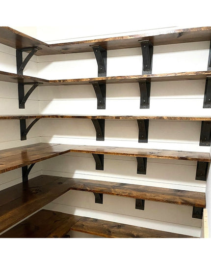 Black metal Cortland shelf brackets with rivets supporting rustic wood shelves in white shiplap pantry corner shelving sys...