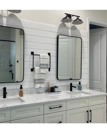 Black metal Parker Hand Towel Holder ladder mounted on white shiplap bathroom wall between two mirrors with folded towels ...