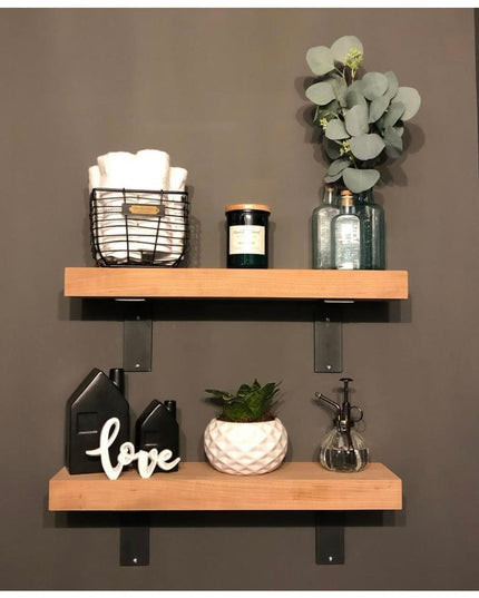 Wood floating shelves with black Lucas L Bracket supports from Industrial Farm Co displaying home decor items including ca...