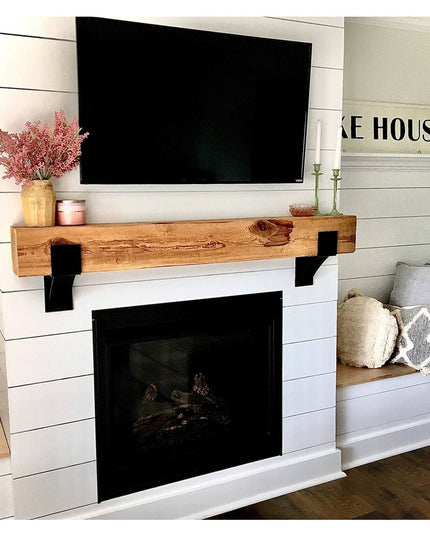 Kudlick Farmhouse wooden mantel with black metal brackets supporting rustic beam above white shiplap fireplace in modern f...