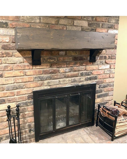 Rustic wood mantel shelf with black Parish Style Bracket Support from Industrial Farm Co mounted on brick fireplace wall