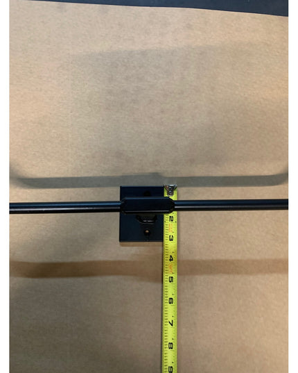 Black metal Fortworth Towel Bar by Industrial Farm Co mounted on wall with measuring tape showing dimensions against beige...