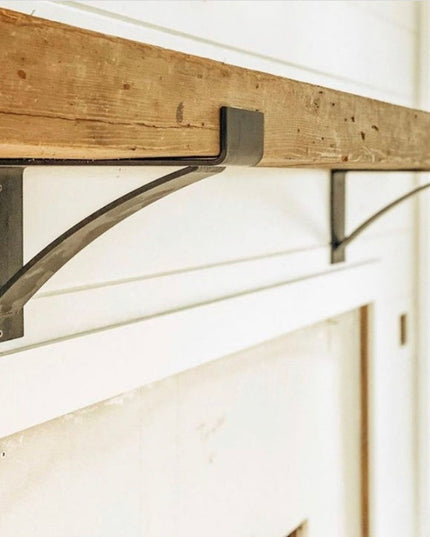 Kudlick Farmhouse Mantel Bracket by Industrial Farm Co - rustic wood beam with curved black metal support brackets mounted...