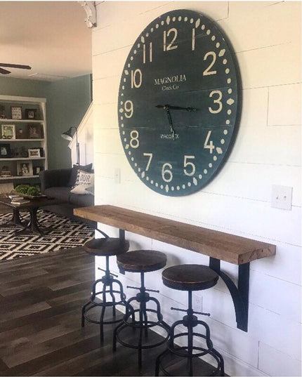 Black metal Rochester countertop brackets supporting rustic wood breakfast bar with industrial stools in farmhouse kitchen...