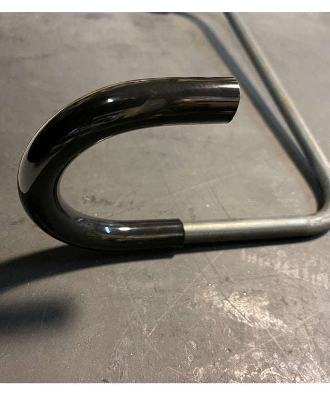 Black powder-coated steel Logan Wall Mounted Bike Rack hook by Industrial Farm Co showing curved design on concrete surface