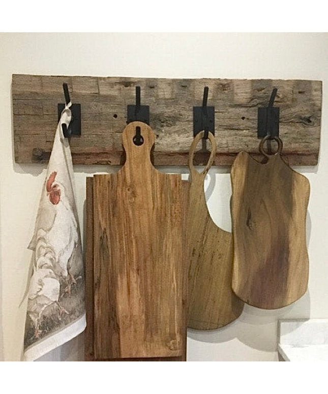 Rustic Felix Wall Hook by Industrial Farm Co with weathered wood backing and black metal hooks holding wooden cutting boar...