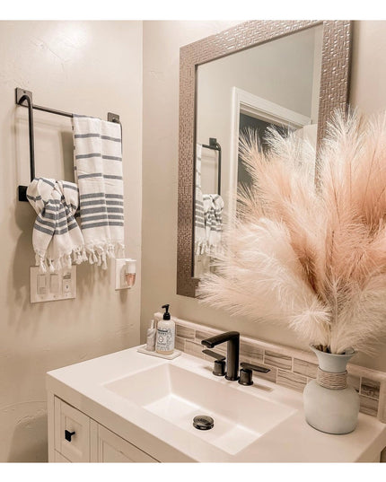 Black metal Parker Hand Towel Holder ladder mounted on beige bathroom wall with striped towels, modern industrial style by...