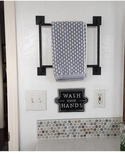 Black metal Parker Hand Towel Ladder mounted on white bathroom wall with geometric patterned towel, Industrial Farm Co dec...