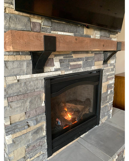 Rustic wood Norfolk Farmhouse Bracket in natural finish supporting wooden mantel on stone fireplace by Industrial Farm Co
