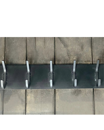 Black metal wall-mounted coat rack with 5 white hooks against weathered wood background - The Bo Style Lodge Coat Rack by ...