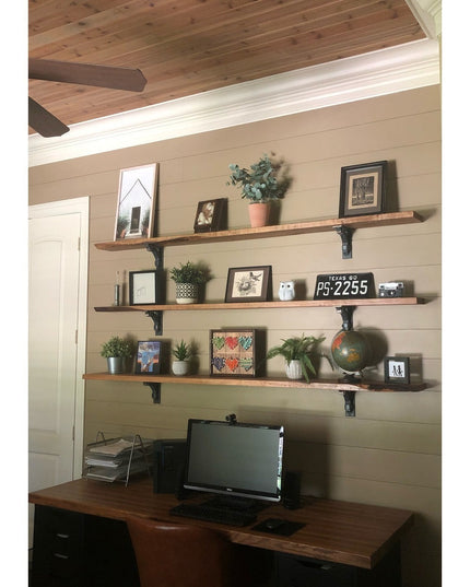 Butch black metal shelf brackets supporting rustic wood shelves with home decor in farmhouse office space by Industrial Fa...