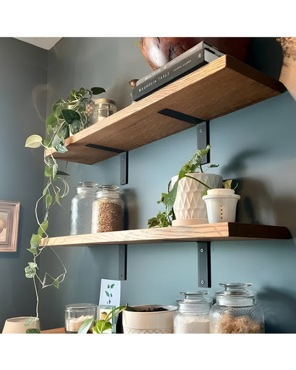 Heavy duty black steel L-bracket shelf supports holding wooden shelves with glass jars, plants and kitchen items on blue w...