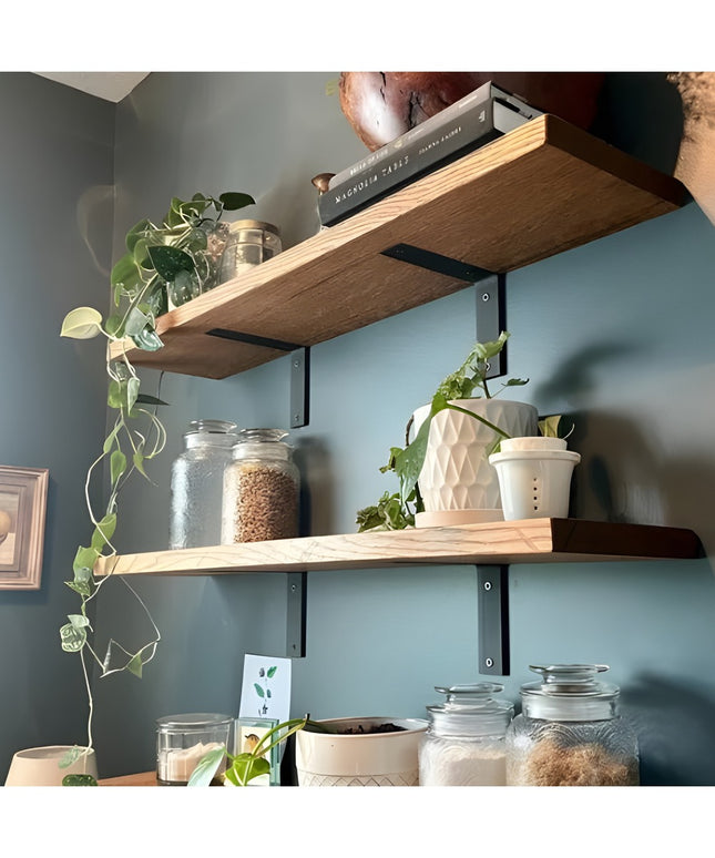 Heavy duty black steel L-bracket shelf supports holding wooden shelves with glass jars, plants and kitchen items on blue w...