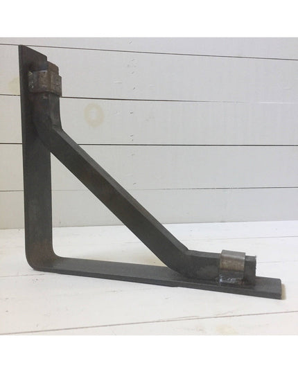 Black metal triangular shelf bracket "The Butch" by Industrial Farm Co mounted on white shiplap wall showing sturdy indust...