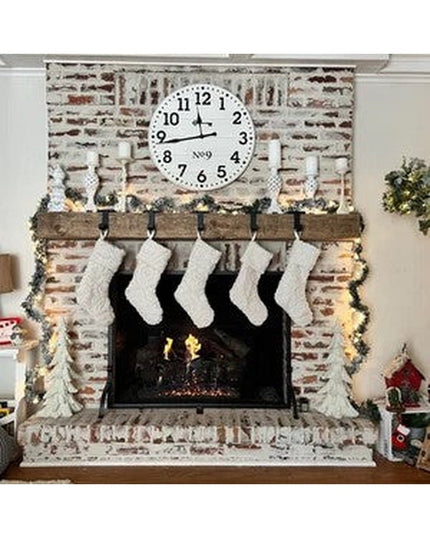Rustic wooden Annie Stocking Holder by Industrial Farm Co mounted on whitewashed brick fireplace mantel with five white kn...