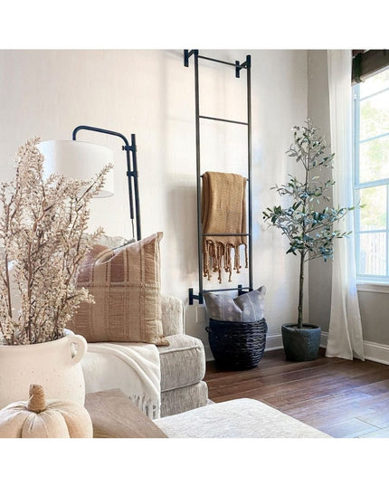 Black metal wall mounted ladder rack with woven beige throw blanket in modern farmhouse living room by Industrial Farm Co