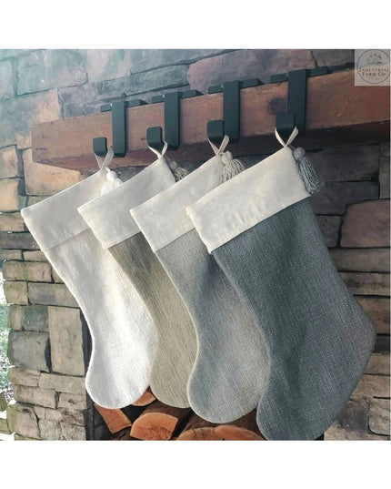 Industrial Farm Co Annie Stocking Holder with four neutral-toned burlap Christmas stockings hanging from black metal hooks...