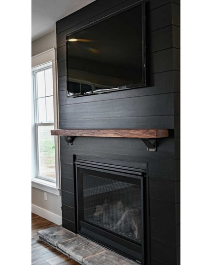 Heavy duty steel Albany 4" industrial shelf brackets with curved support bar holding rustic wood mantel above black firepl...