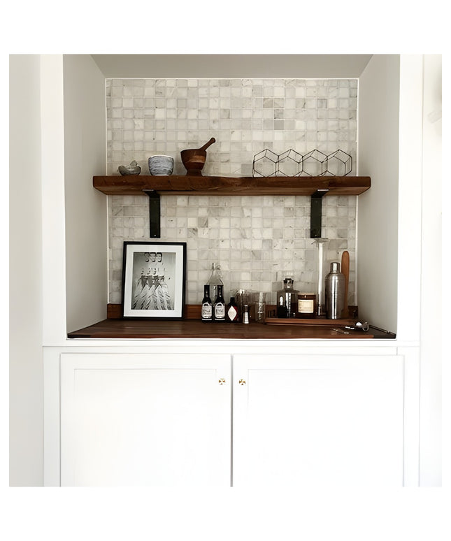 Modern built-in bar nook with white marble mosaic tile backsplash, dark wood floating shelves on black steel brackets, whi...
