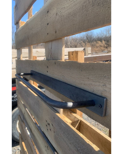 Black metal Oswego Modern Bathroom Towel Bar by Industrial Farm Co mounted on white wooden deck railing outdoors