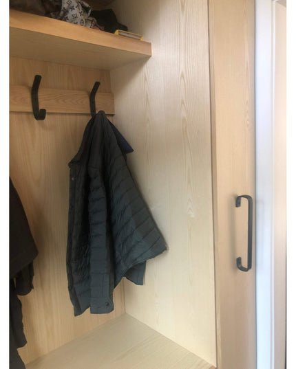 Black Long Beach Handle door pull by Industrial Farm Co mounted on light wood closet door with hanging jacket and storage ...