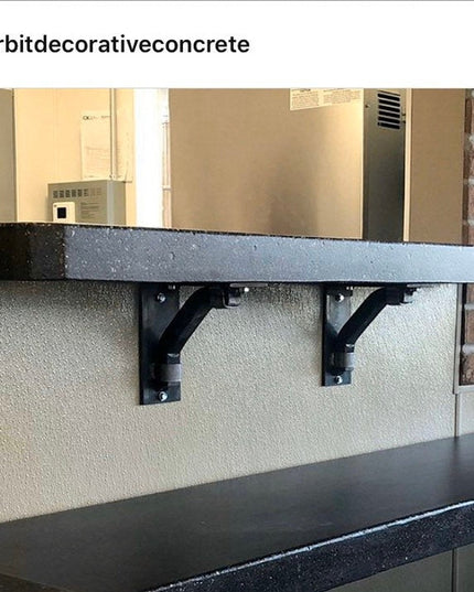 Black industrial concrete shelf mounted on brick wall with metal bracket supports from Industrial Farm Co, showing Hornell...