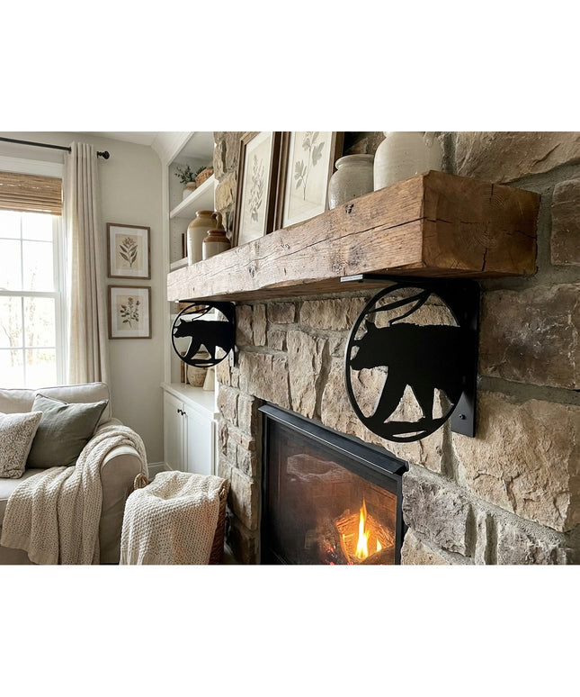 Black metal bear cutout L-bracket shelf supports holding rustic wood mantel on stone fireplace in cozy living room