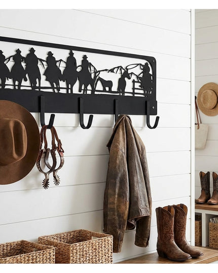Western Charm black metal wall-mounted coat rack with cowboy silhouette cutout displaying cowboy hat, jacket, and spurs in...