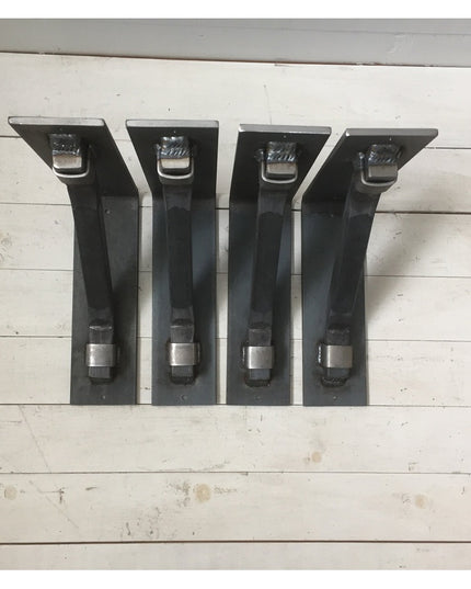 Four black metal Hornell Industrial Shelf Support brackets with mounting hardware displayed on white wooden planks by Indu...