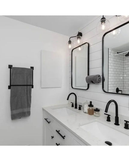 Black metal Parker Hand Towel Holder ladder-style rack mounted on white subway tile bathroom wall with gray towel displayed
