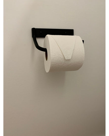 Black metal Howlett Hill toilet paper holder by Industrial Farm Co mounted on white wall with white toilet paper roll