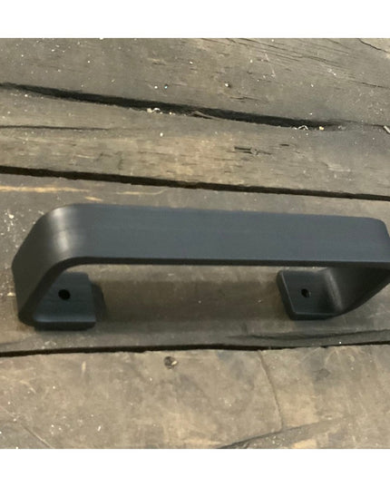 Black metal Emma towel holder door pull with curved design and mounting brackets on weathered wood surface by Industrial F...