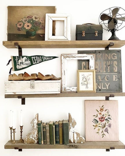 Three rustic wooden floating shelves with black metal KT Z Style Shelf Supports displaying vintage decor, books, and colle...
