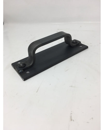 Black cast iron Corning Handle door pull with curved design and mounting screws by Industrial Farm Co on white background