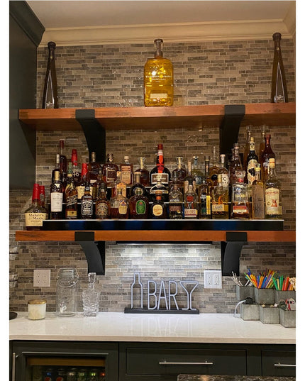 Norfolk Farmhouse Bracket by Industrial Farm Co supporting wooden floating shelves with extensive whiskey bottle collectio...
